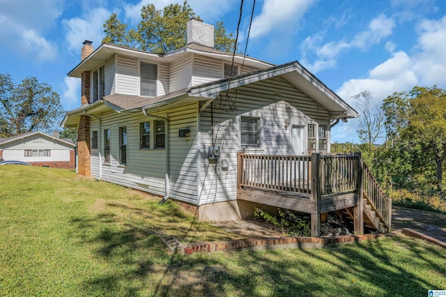 back of house featuring a deck and a lawn