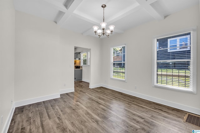 spare room with beamed ceiling, coffered ceiling, hardwood / wood-style flooring, and an inviting chandelier