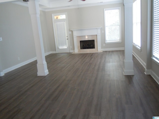 unfurnished living room with ornate columns, crown molding, dark hardwood / wood-style floors, and ceiling fan