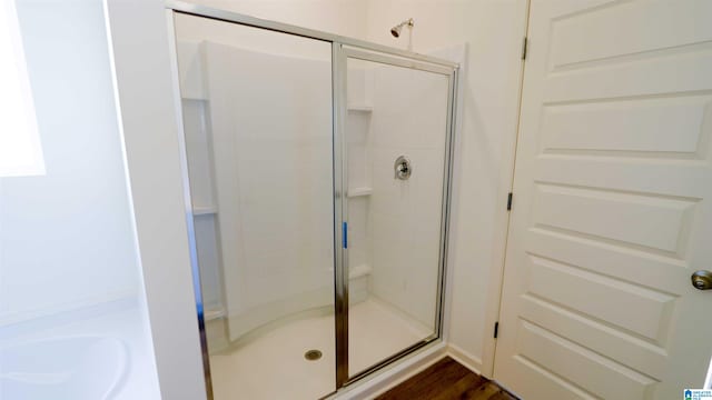 bathroom featuring hardwood / wood-style flooring and a shower with shower door