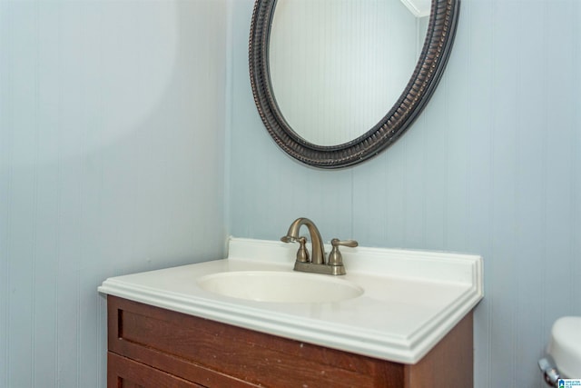 bathroom featuring vanity and wood walls