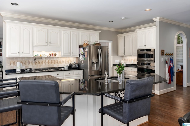 kitchen with white cabinetry, stainless steel appliances, dark wood-type flooring, and backsplash