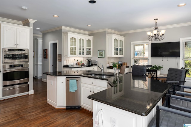 kitchen featuring a kitchen island with sink, sink, pendant lighting, white cabinets, and dark hardwood / wood-style flooring