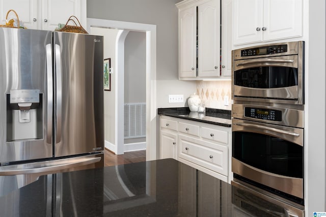 kitchen with white cabinetry, appliances with stainless steel finishes, and dark hardwood / wood-style floors