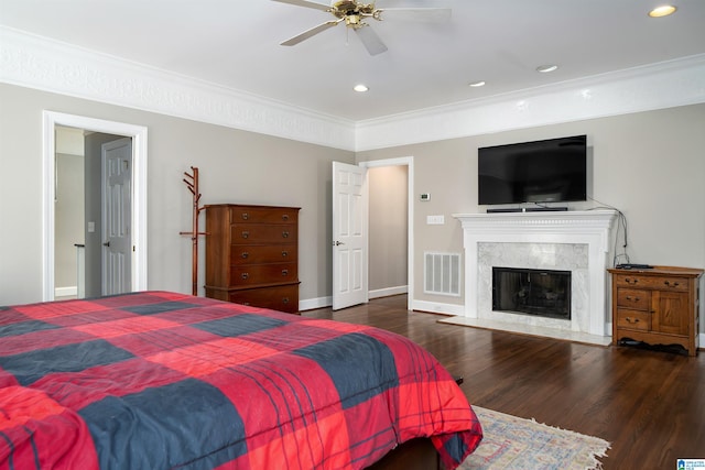 bedroom with a premium fireplace, ceiling fan, and dark hardwood / wood-style flooring