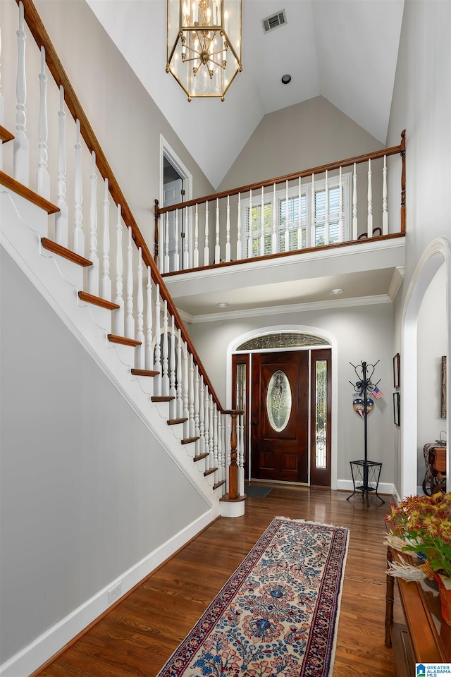 foyer entrance featuring a wealth of natural light, an inviting chandelier, dark hardwood / wood-style floors, and high vaulted ceiling