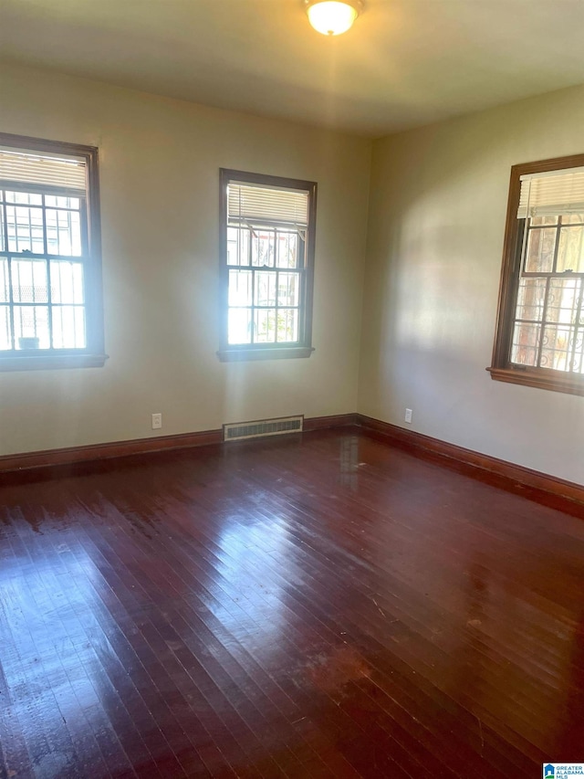 unfurnished room featuring dark hardwood / wood-style flooring and plenty of natural light