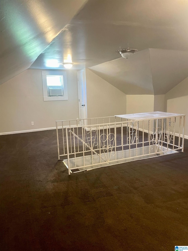 bonus room with dark carpet and lofted ceiling