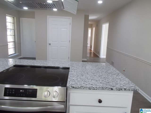 kitchen featuring stainless steel range, white cabinets, light stone countertops, and dark hardwood / wood-style flooring