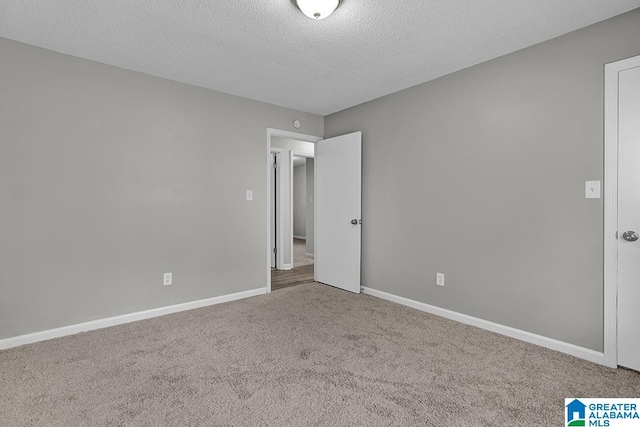 carpeted spare room featuring a textured ceiling