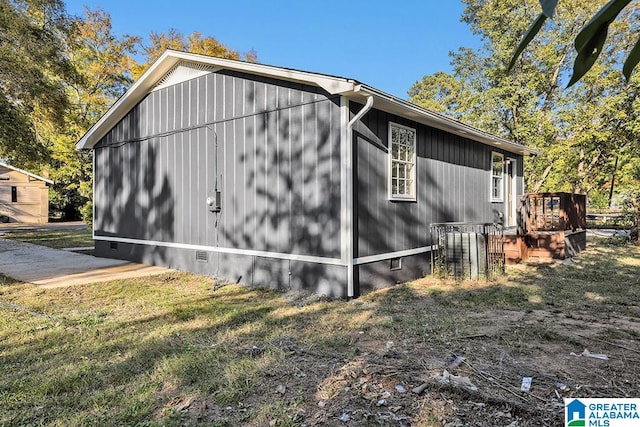 view of side of home featuring a deck and a lawn