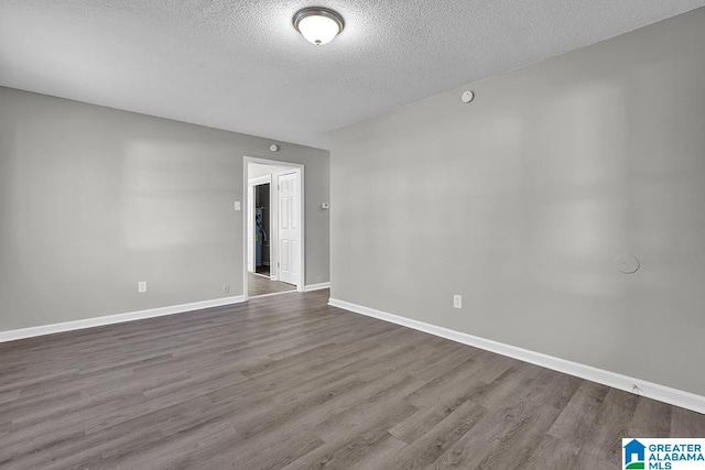 spare room with a textured ceiling and wood-type flooring