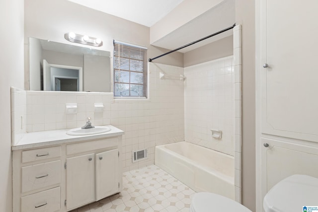 full bathroom featuring shower / washtub combination, toilet, vanity, tile walls, and tasteful backsplash