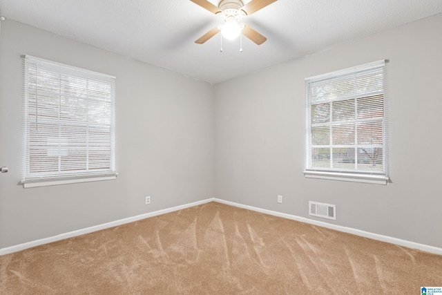 empty room with ceiling fan and light carpet