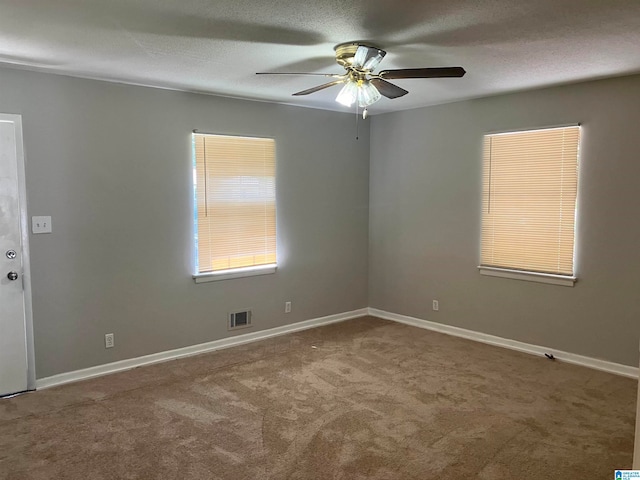 empty room featuring a textured ceiling, ceiling fan, and carpet floors