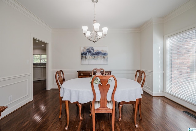 dining area featuring a notable chandelier, ornamental molding, and dark hardwood / wood-style flooring