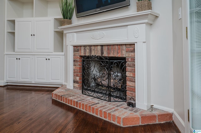 interior details with hardwood / wood-style flooring, built in features, and a brick fireplace