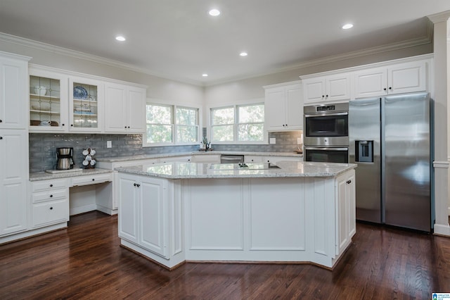 kitchen with a center island, dark wood-type flooring, appliances with stainless steel finishes, and white cabinetry