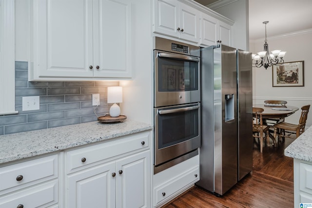 kitchen featuring hanging light fixtures, white cabinetry, dark wood-type flooring, crown molding, and stainless steel appliances