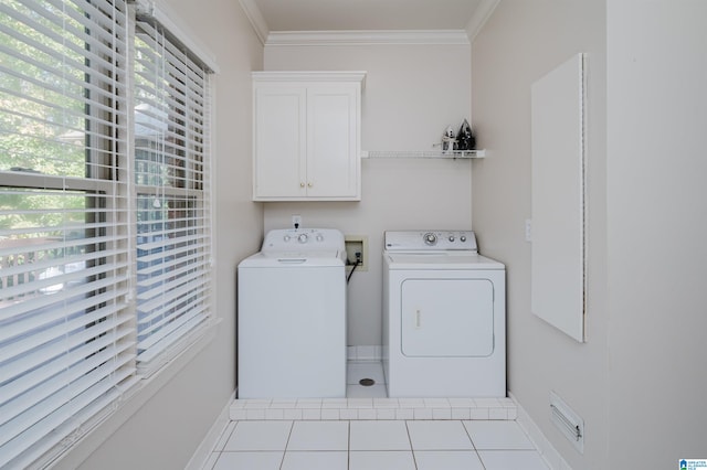 laundry area featuring cabinets, crown molding, light tile patterned flooring, and washer and clothes dryer