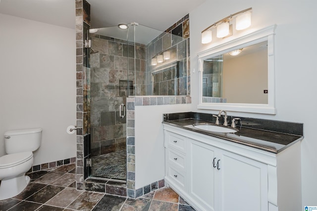 bathroom with toilet, a shower with shower door, and vanity