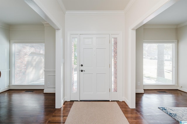 entryway with ornamental molding and dark hardwood / wood-style floors