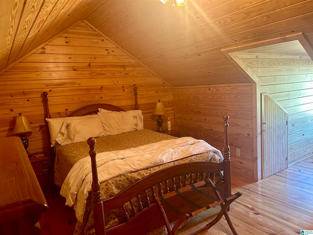 bedroom with wood walls, wooden ceiling, hardwood / wood-style floors, and vaulted ceiling