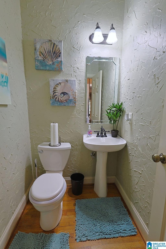 bathroom with toilet and hardwood / wood-style flooring