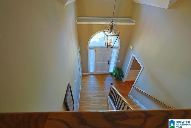 entrance foyer with hardwood / wood-style flooring, a high ceiling, and an inviting chandelier