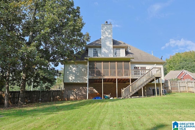 rear view of house with a wooden deck, a yard, and a sunroom