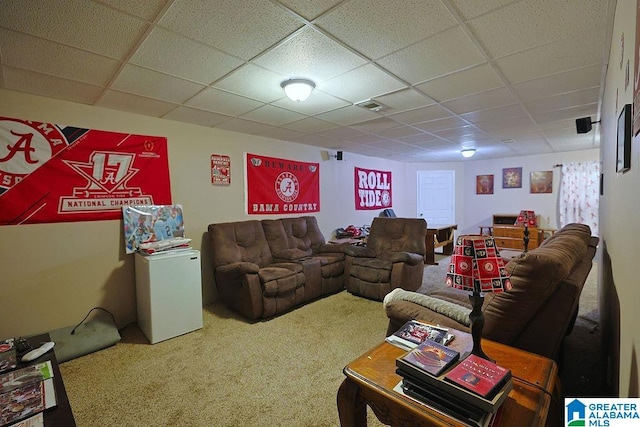 carpeted living room featuring a drop ceiling