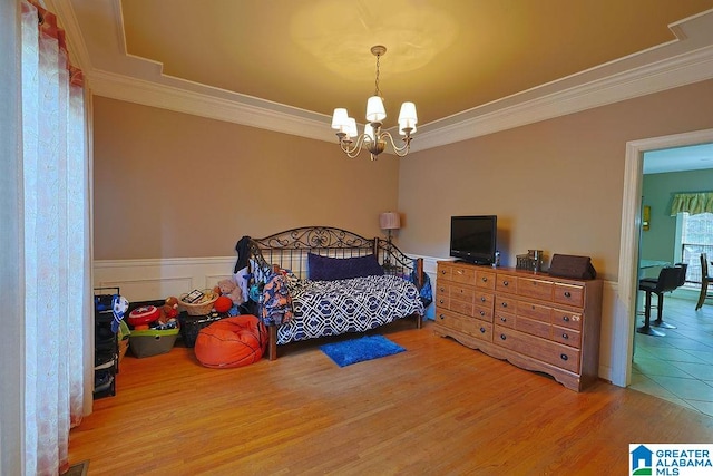 bedroom with hardwood / wood-style floors, crown molding, and a chandelier