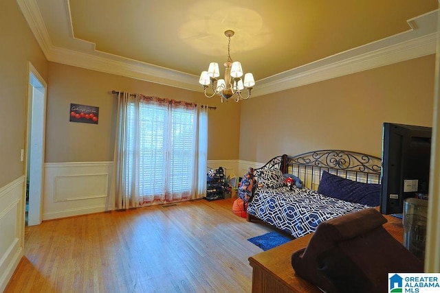 bedroom featuring a notable chandelier, ornamental molding, and hardwood / wood-style flooring