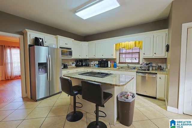 kitchen featuring a center island, appliances with stainless steel finishes, and white cabinetry