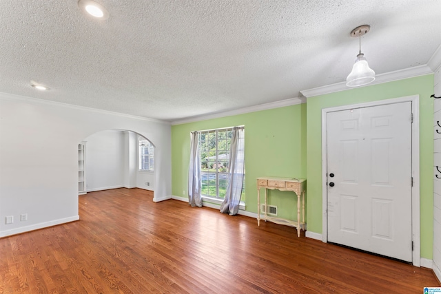 entrance foyer with a textured ceiling, ornamental molding, and hardwood / wood-style floors