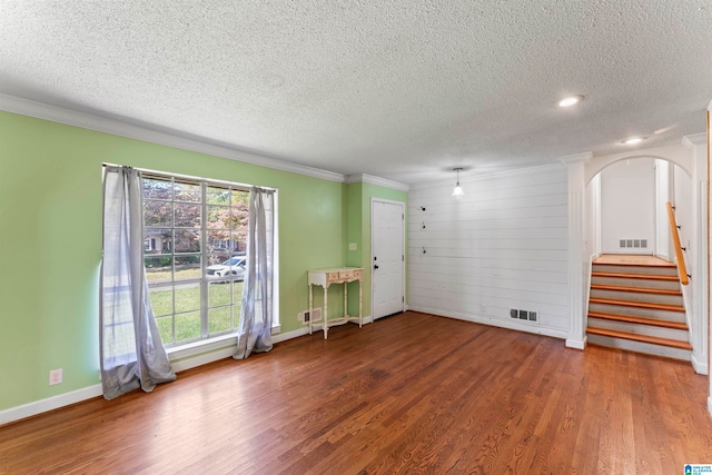 unfurnished room with crown molding, dark hardwood / wood-style floors, and a textured ceiling