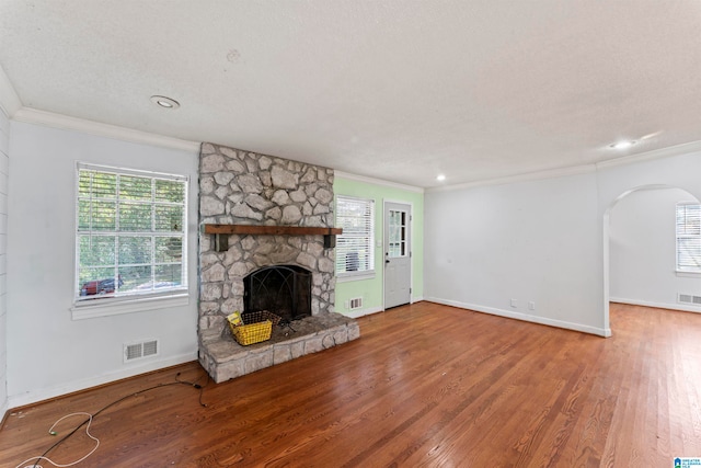 unfurnished living room with crown molding, hardwood / wood-style floors, a textured ceiling, and a fireplace