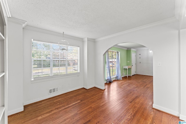 spare room with ornamental molding, a textured ceiling, and dark hardwood / wood-style floors