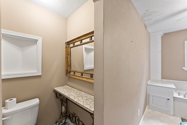 bathroom featuring toilet, a textured ceiling, vanity, and tile patterned flooring