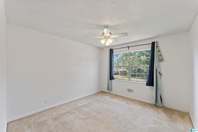 carpeted spare room featuring ceiling fan and a textured ceiling