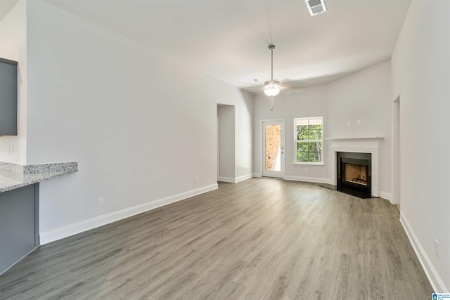 unfurnished living room with wood-type flooring and ceiling fan