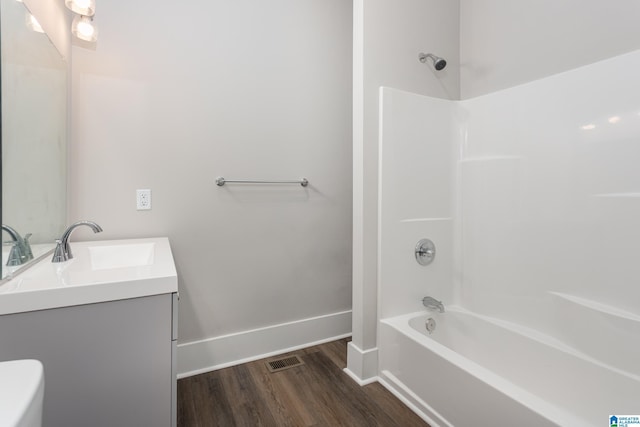 8321 Division Ave, Birmingham, AL 35206 - full bath featuring washtub / shower combination, baseboards, toilet, wood finished floors, and vanity