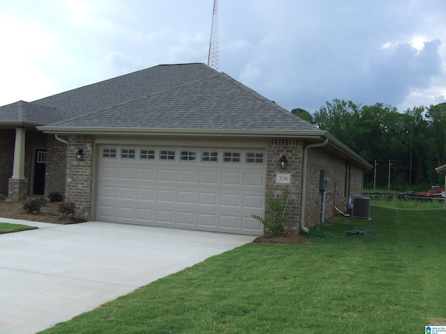 view of side of property featuring a yard, central AC unit, and a garage