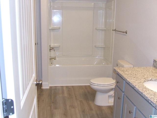 full bathroom with shower / bathing tub combination, vanity, hardwood / wood-style flooring, and toilet