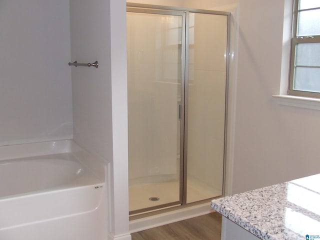 bathroom with vanity, independent shower and bath, and wood-type flooring