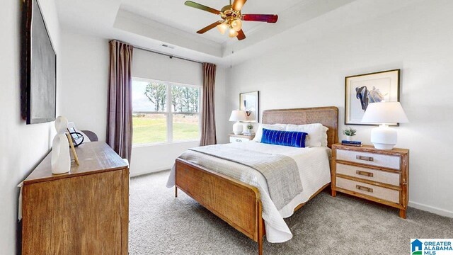 bedroom with light carpet, a raised ceiling, a ceiling fan, and baseboards