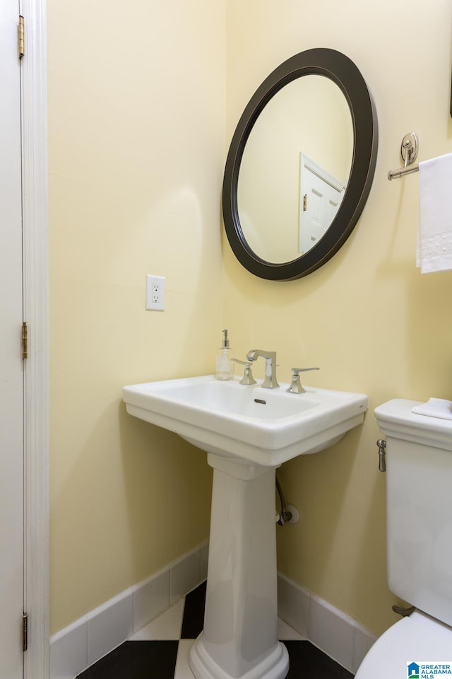 bathroom with toilet and tile patterned floors