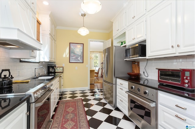 kitchen featuring custom exhaust hood, hanging light fixtures, appliances with stainless steel finishes, white cabinetry, and sink