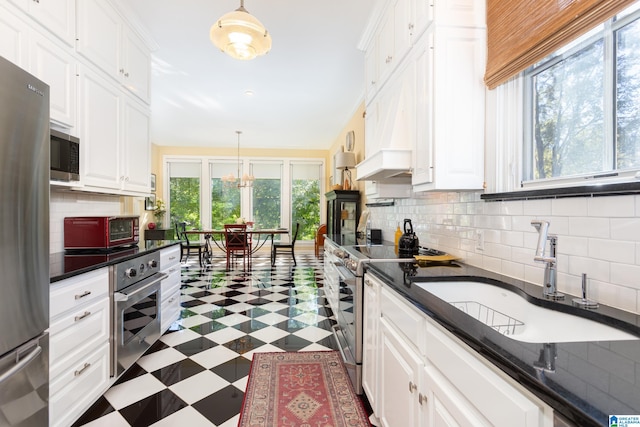 kitchen with stainless steel appliances, pendant lighting, and white cabinets