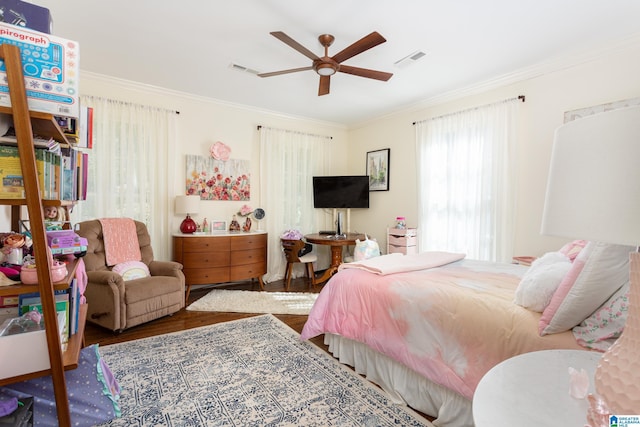 bedroom featuring ornamental molding, a ceiling fan, visible vents, and wood finished floors